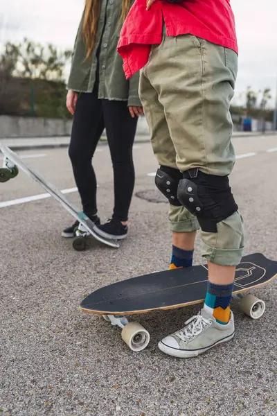 Kvinna Med Skateboard Bär Skyddande Knäskydd När Står Vid Kvinnlig — Stockfoto