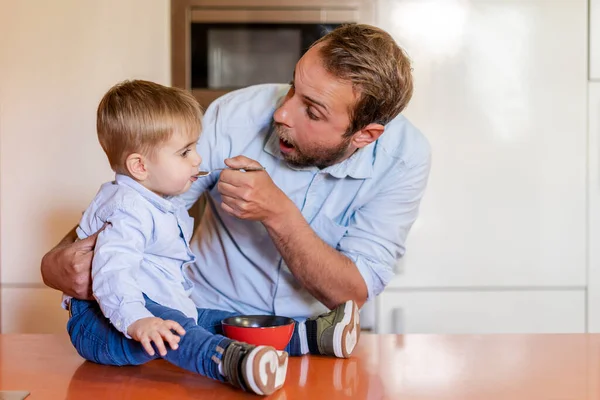 Surprised Father Feeding Son Table Home — Stock Photo, Image