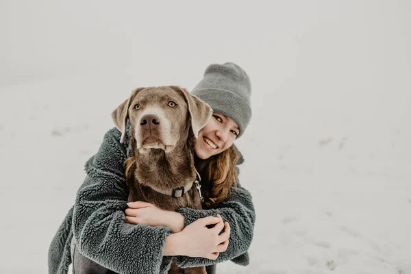 Portrait Teenage Girl Crouching Snow Embracing Labrador Retriever — Stock Photo, Image