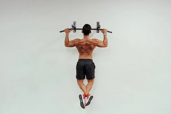 白い壁に運動器具であごアップを行う中高年スポーツマン — ストック写真