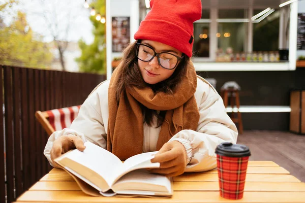 Kobieta Okularach Czyta Książkę Podczas Siedzenia Kawiarni Chodnikowej — Zdjęcie stockowe
