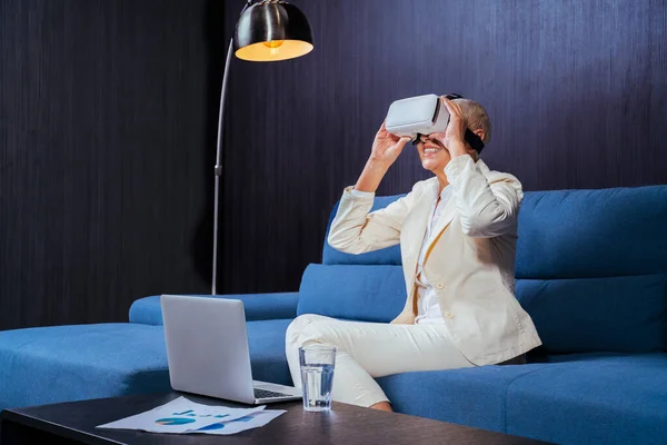 Smiling Businesswoman Using Virtual Reality Headset While Sitting Laptop Sofa — Stock Photo, Image