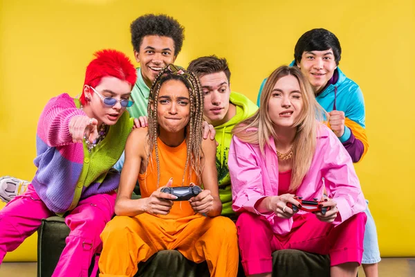 Kvinnor Som Håller Gamepad Medan Sitter Med Vänner Framför Gul — Stockfoto