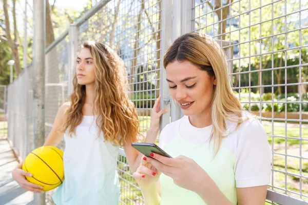 Donna Che Utilizza Telefono Cellulare Mentre Piedi Con Amico Background — Foto Stock