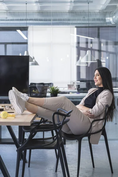 Ayakları Havada Gülümseyen Kadını Çalışma Masasında Otururken Başka Tarafa Bakıyor — Stok fotoğraf