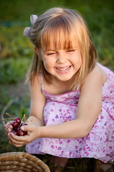 Chica Sonriente Mirando Hacia Otro Lado Sosteniendo Cerezas Mientras Agacha —  Fotos de Stock