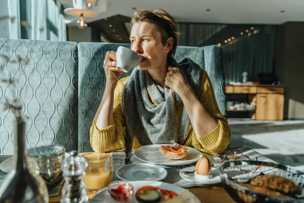 Mulher Bebendo Café Mesa Enquanto Olha Para Longe Quarto Hotel — Fotografia de Stock