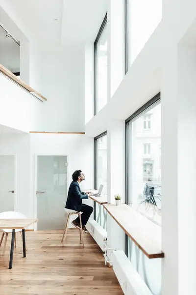 Male Entrepreneur Sitting Laptop Office Looking Window — Stock Photo, Image