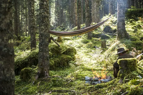 Człowiek Relaksujący Się Przed Kamiennym Ogniskiem Płonącym Lesie — Zdjęcie stockowe