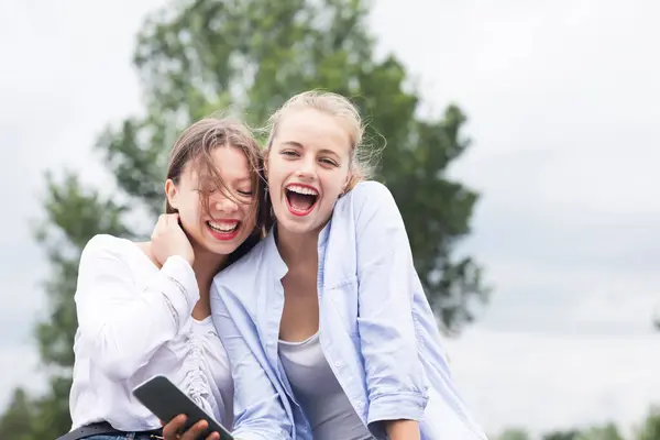 Vrouwelijke Vrienden Lachen Terwijl Het Houden Van Smart Phone Natuur — Stockfoto