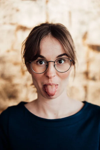 Mujer Joven Con Anteojos Que Sobresalen Lengua —  Fotos de Stock