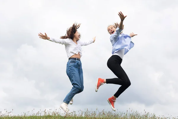 Despreocupado Jóvenes Amigas Saltando Sobre Hierba — Foto de Stock