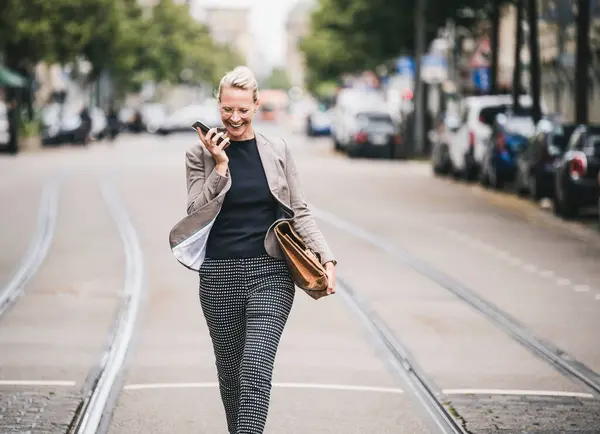 Wesoła Kobieta Dojeżdżająca Pracy Rozmawia Przez Telefon Komórkowy Podczas Spaceru — Zdjęcie stockowe