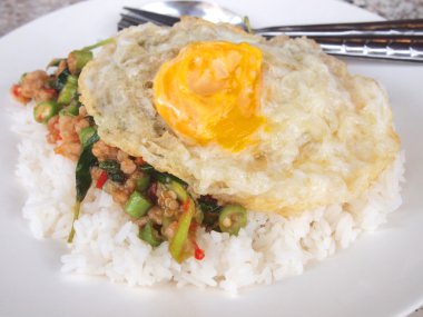 Pirinç karıştırın kızarmış domuz eti ve fesleğen ile tepesinde kapatın