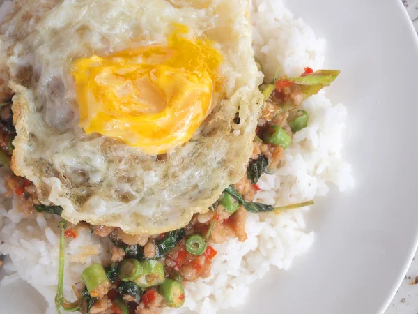 Pirinç karıştırın kızarmış domuz eti ve fesleğen ile tepesinde kapatın