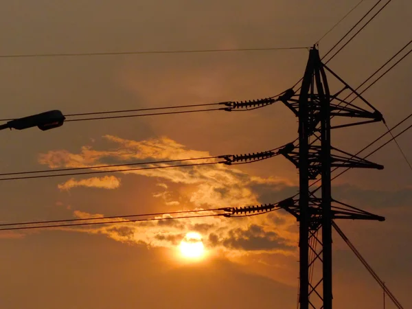 Silhouette della torre elettrica ad alta tensione con bellissimo sfondo tramonto — Foto Stock