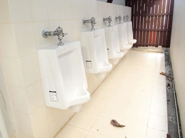 Линия белых фарфоровых писсуаров в общественных туалетах — стоковое фото