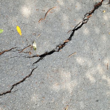 eski ıslak yıpranmış ve kırık asfalt ile çatlaklar