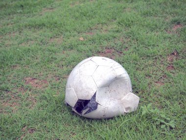 Çimenlerin üzerinde kırık futbol topu