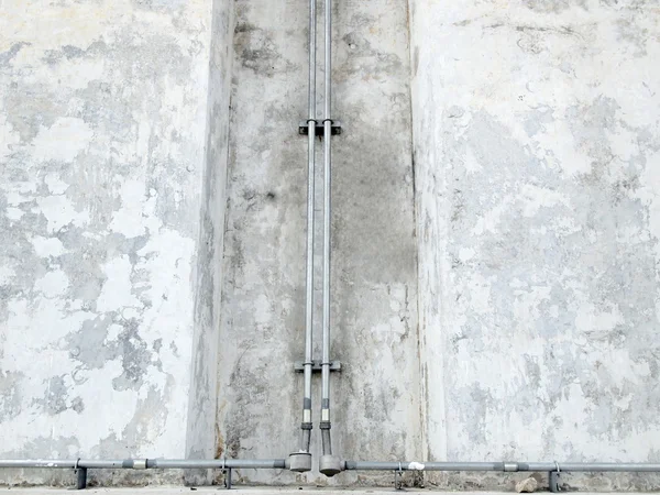Sanitärrohr gegen Stuckwand, industrieller Grunge-Hintergrund — Stockfoto