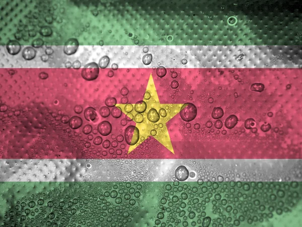 Tetes air di latar belakang bendera Suriname — Stok Foto