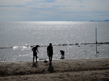 Kumsalda yürüyen insanlar