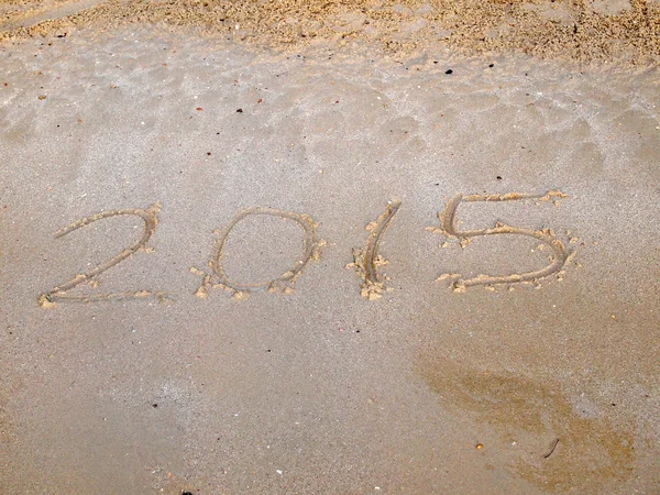 Año 2015 escrito en arena — Foto de Stock