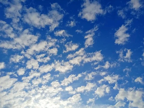 Mavi gökyüzüne karşı beyaz bulutlar. Parlak gökyüzü. — Stok fotoğraf