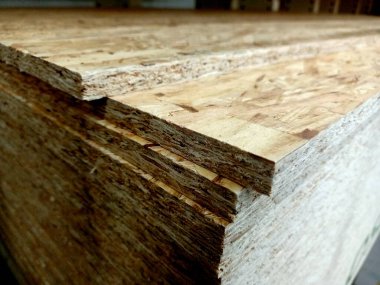 İnşaat için bir yığın kontrplak. Tahta yonga çarşaf yığını. Osb kontrplak.