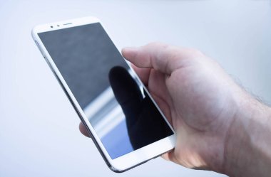 Siyah ekranlı beyaz akıllı telefon. Elinde boş ekran olan telefon.