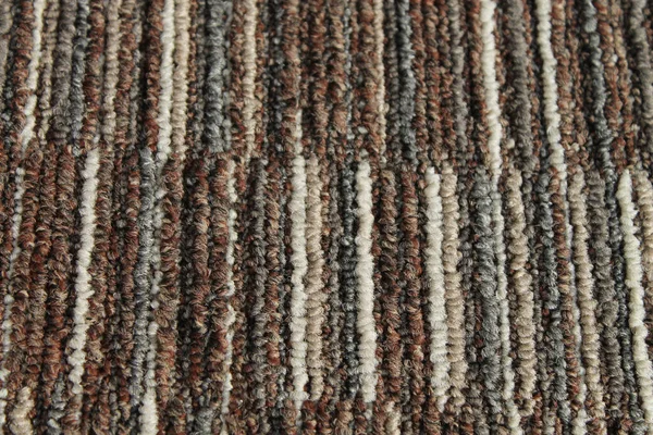 Texture of carpet floor close-up. Brown carpet with a pattern. Geometric shapes on the carpet.