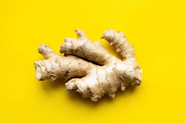 Ginger root on a yellow background. Gingerbread on an isolated background. Root for the treatment of diseases. Healing ginger root.