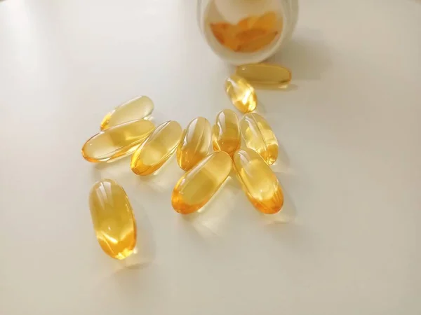 Fish oil capsules. Medicinal pills from the pharmacy to restore health. Yellow capsules on a white background.