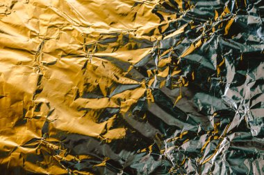Buruşmuş folyo dokusu. Buruşuk kağıt renkli bir renkle parlar. Renkli yansımalı folyo.