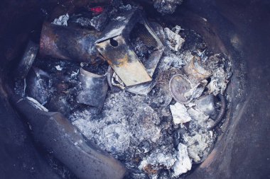 Yanmış çöp. Yanmış çöp kalıntıları. Ev atıkları. Atık öğütücü. Çöpler varilde. Çöp tenekesine atık atmak.