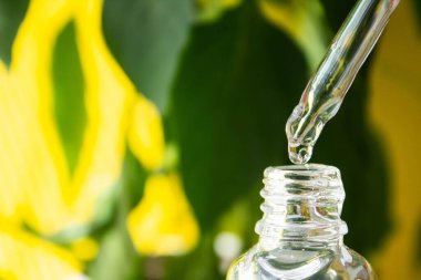 Test tüpünden serum damlıyor. Yüzüne merhem sür. Kırışıklık önleyici krem. Yakın plan düşür.