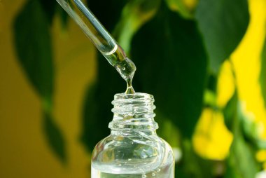 Test tüpünden serum damlıyor. Yüzüne merhem sür. Kırışıklık önleyici krem. Yakın plan düşür.