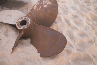 Eski gemi motoru pervanesi. Kumda paslı bıçaklar. Okyanustaki bir geminin enkazı. Denizde batmış bir gemi.