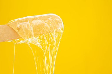 Karıştırıcı macun. Vücut kılları alınıyor. Depilasyon. Hamur, şekerli spatuladan damlıyor. Vücut bakım ürünleri.