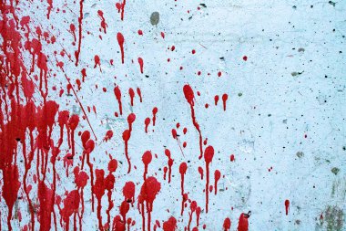 Duvarda kırmızı lekeler var. Boya damlaları aşağı akıyor. Duvarda kırmızı kan var. Kirli beton duvar.