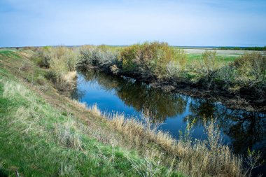 Nehir köyde. Nehre giden yol. Baharda köy. Bir vadide küçük bir nehir.