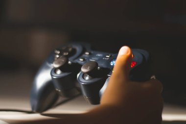 Çocuk bir bilgisayar oyunu oynuyor. Joystick elinde. Bilgisayar kulübünde bir oyuncu. Çocuk Oyunları.