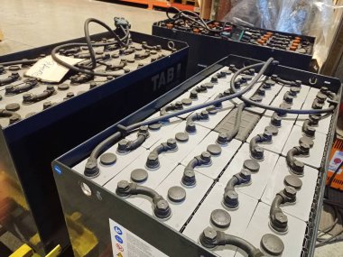 Endüstriyel depolama pilleri. Elektrikli forkliftin pilini şarj ediyorum. Depo ekipmanları. Büyük pil şarj edildi.