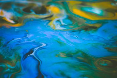 Dökülmüş boyanın soyut arkaplanı. Tuval üzerinde çok renkli boyalar.