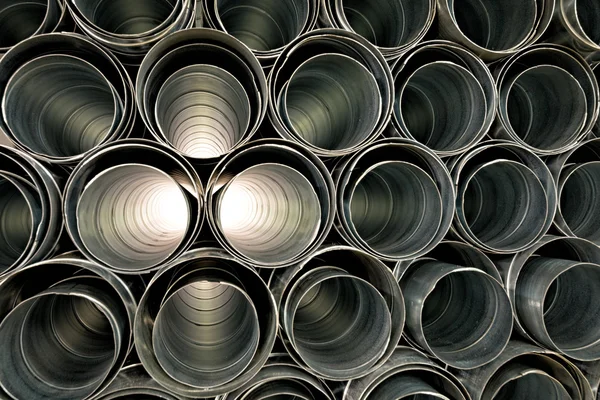 Tubos metálicos apilados en filas patrón — Foto de Stock