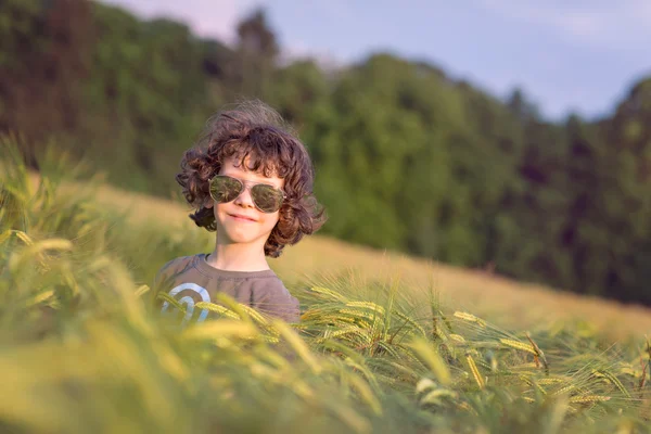 Chłopiec grający na złożony w zachód słońca, okulary — Zdjęcie stockowe