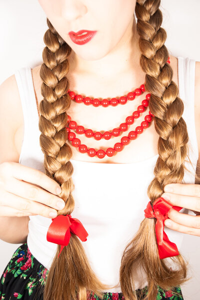 A young beautiful woman with long blonde hair tresses wearing a Polish folk costume