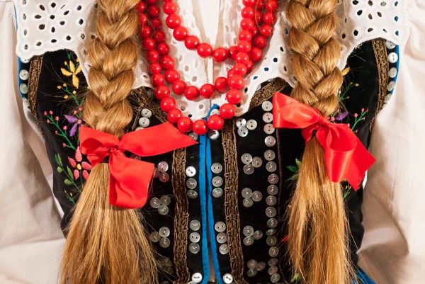 Una donna con lunghe trecce che indossa un costume tradizionale polacco — Foto Stock