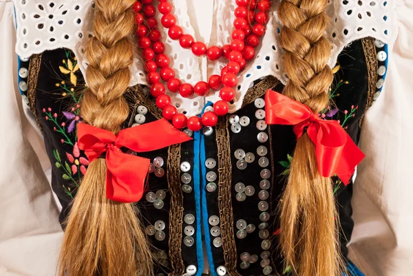 Een vrouw met lange tresses draagt een traditionele Poolse folk kostuum — Stockfoto