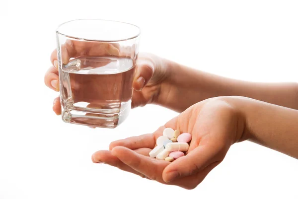 Mains avec des médicaments et un verre d'eau Image En Vente